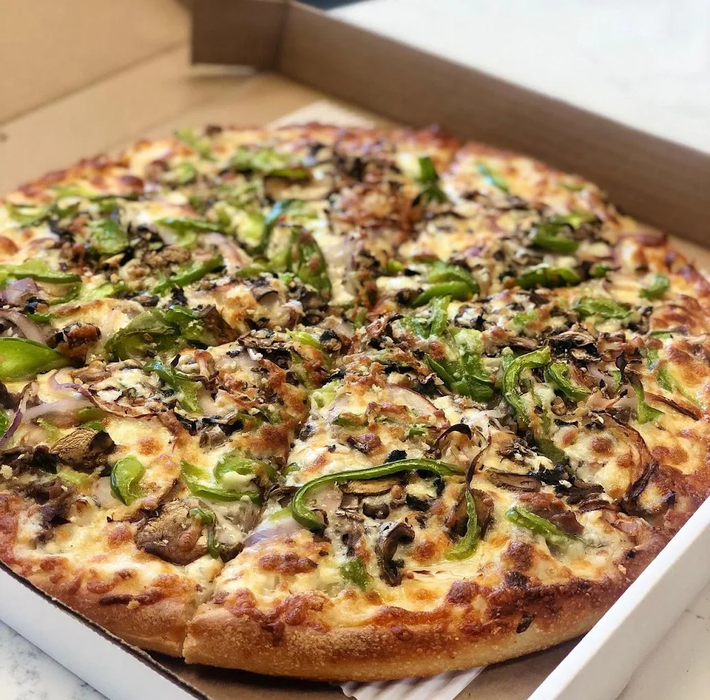 Baked Mediterranean penne pasta with pesto, chicken, peppers and cheese at New York Pizzeria